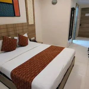 Well-maintained hotel room with clean bedding at Vinayaga by Poppys Kumbakonam